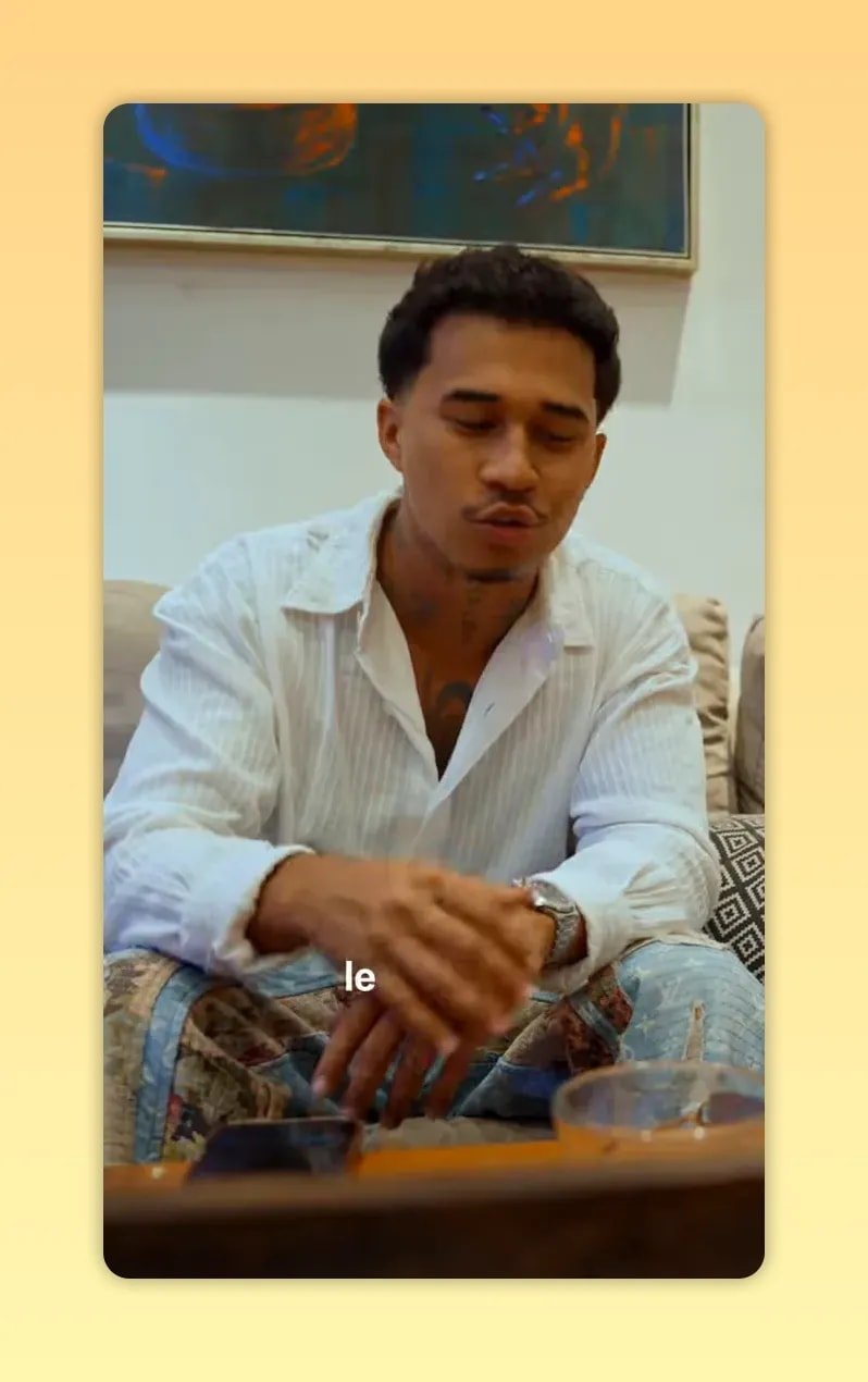 Homme en chemise blanche assis sur un canapé, regard vers l’avant, avec un sous-titre en bas de l’image